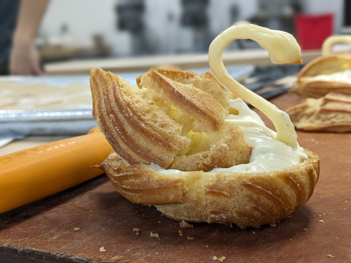 A pastry with a swan shaped object Description automatically
generated